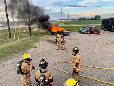 firefighters around car on fire